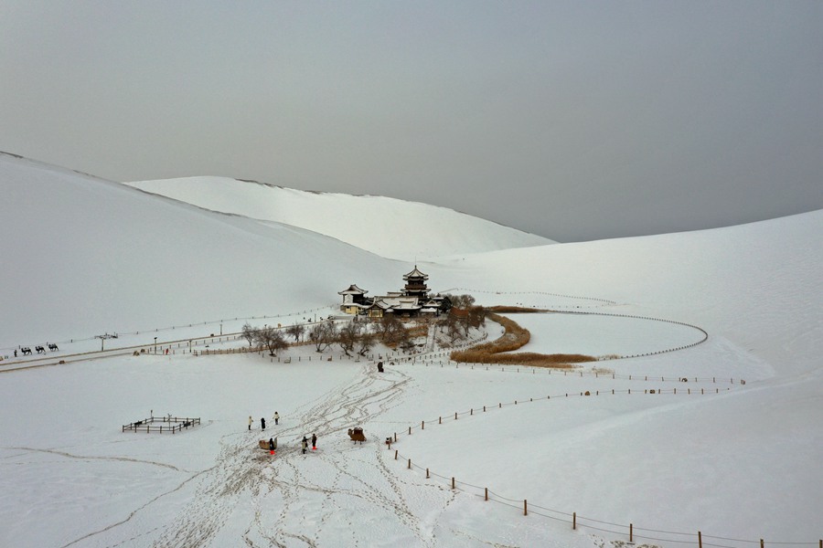 雪后的甘肅省敦煌市鳴沙山月牙泉景區(qū)銀裝素裹，景色如畫(huà)。張曉亮攝